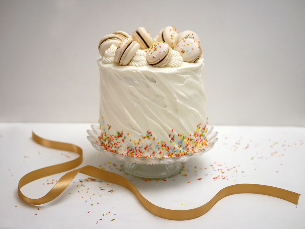 Chocolate cake with whipped cream frosting and macarons