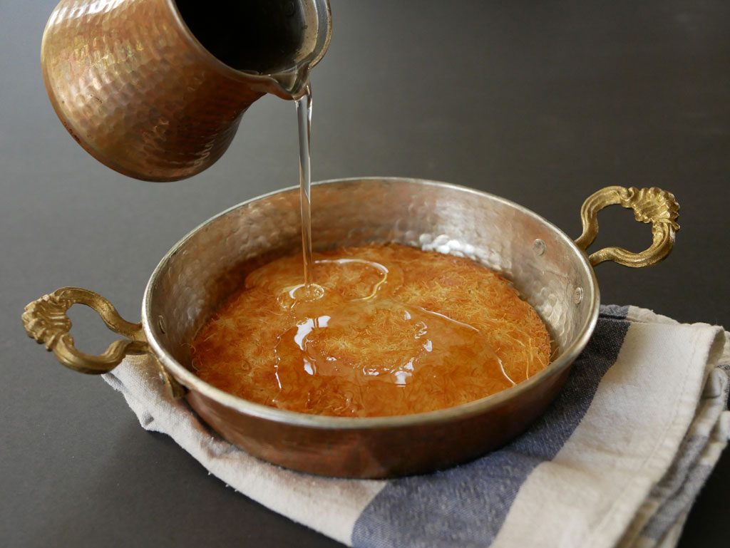 Pouring Sugar syrup on knafeh