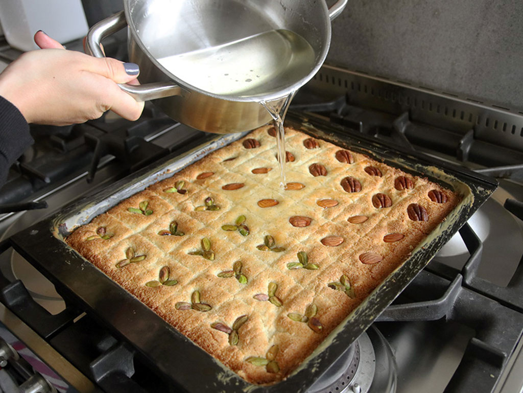 Pouring the syrup on basbousa